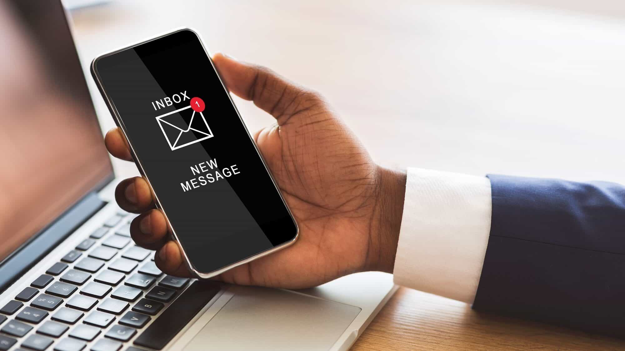 Black Businessman Holding Smartphone Reading E-Mail Message In Office